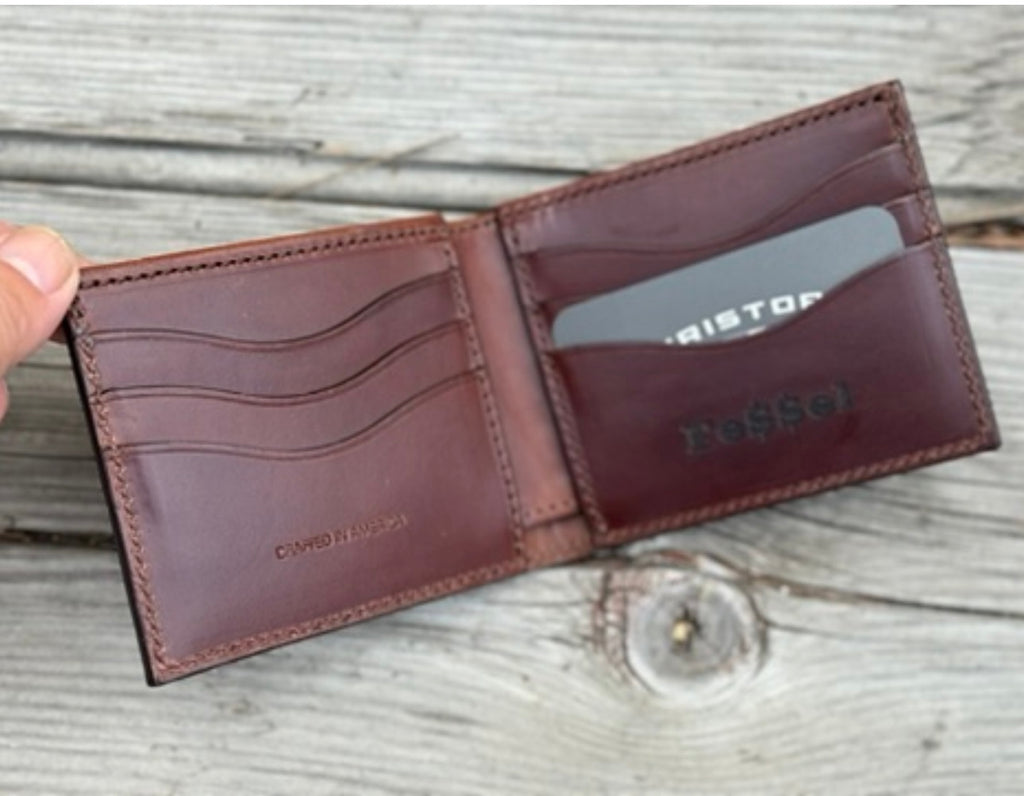 Brown leather wallet with visible branding on a wooden surface
