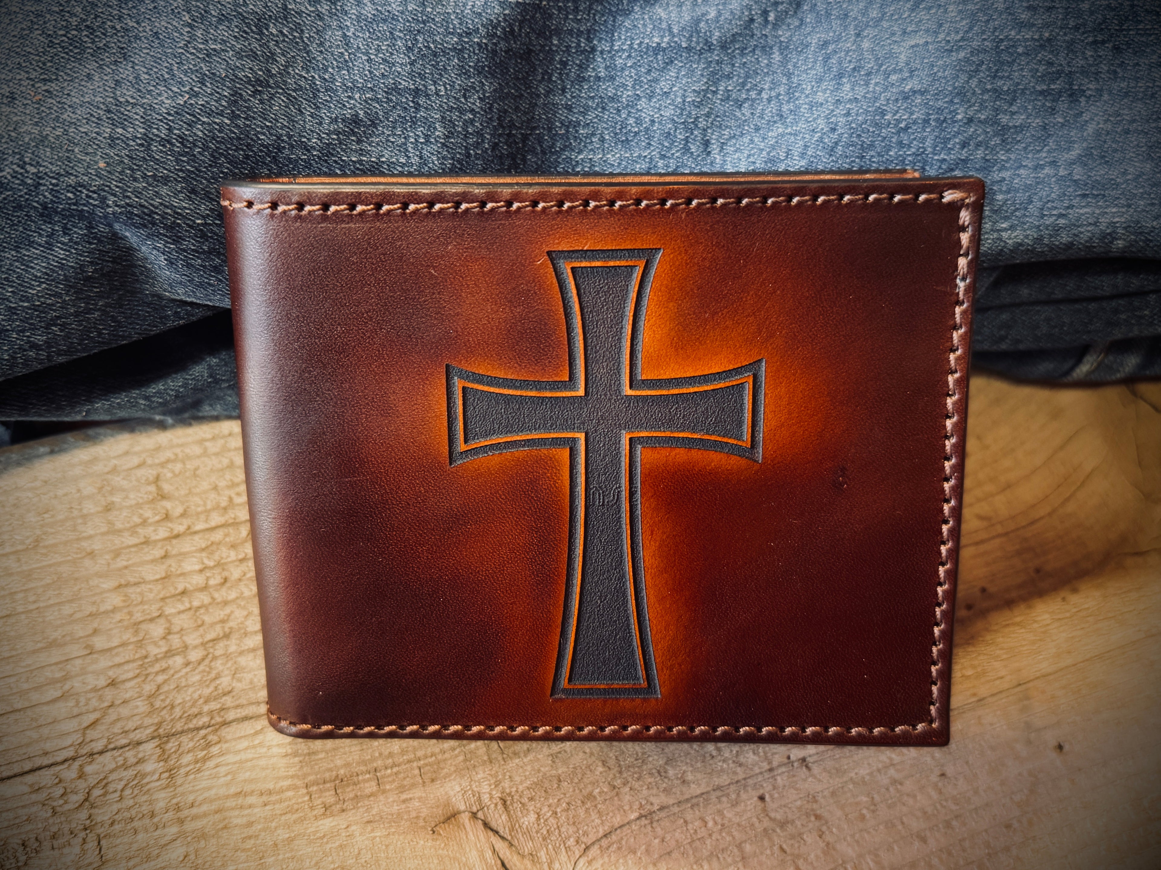 Brown leather wallet with a cross design and Angel on a leather  surface