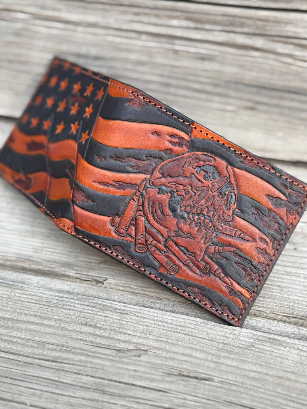 Leather wallet with American flag and skull design on a wooden surface