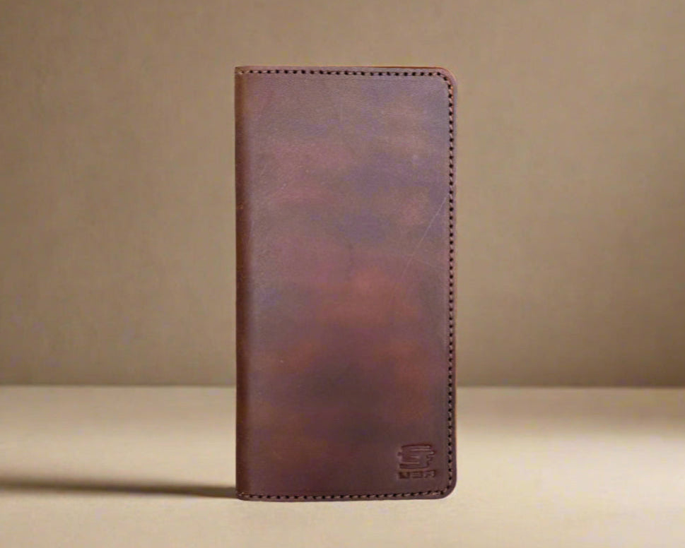 Christoph Joseph Brown leather wallet on a beige background