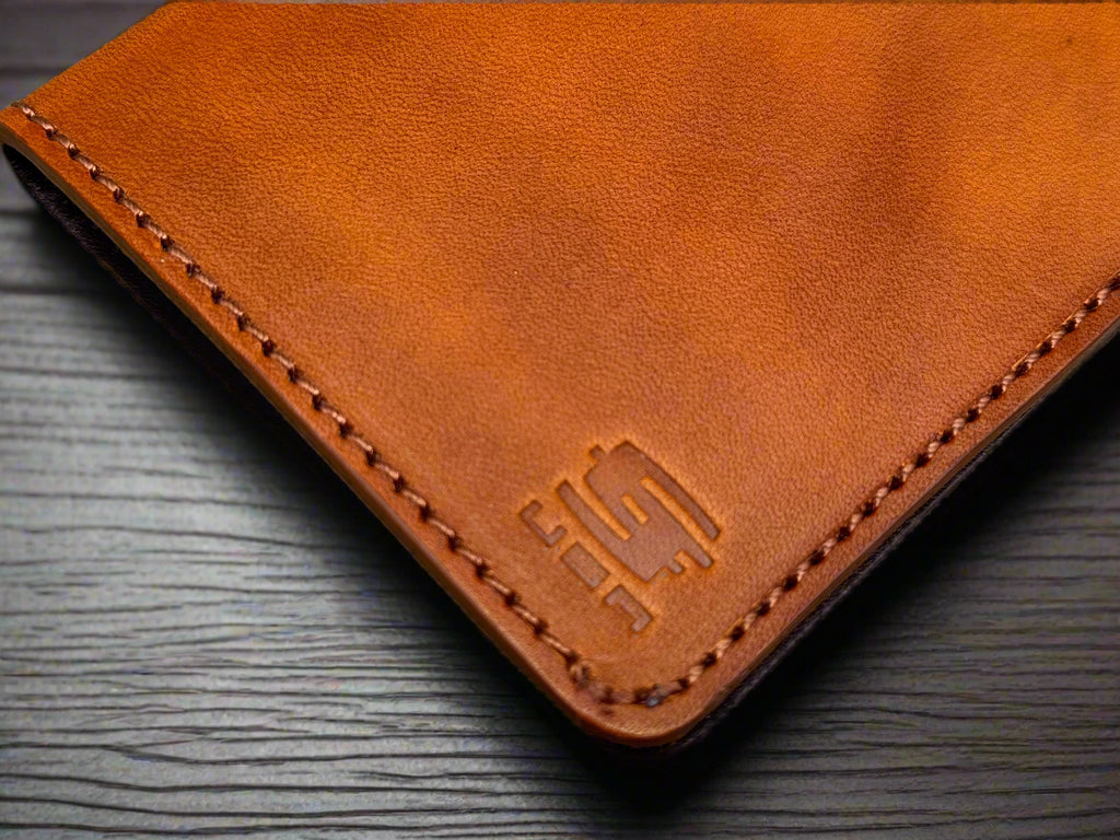 Tan leather long wallet with a Christoph Joseph brand logo on a wooden surface